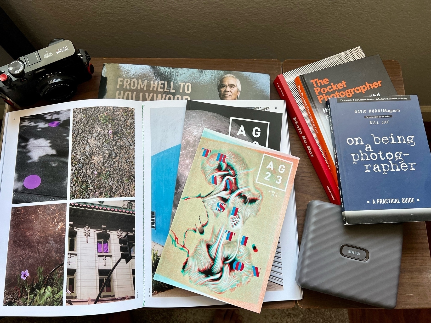 a small table top covered in a variety of photography books and zines. 